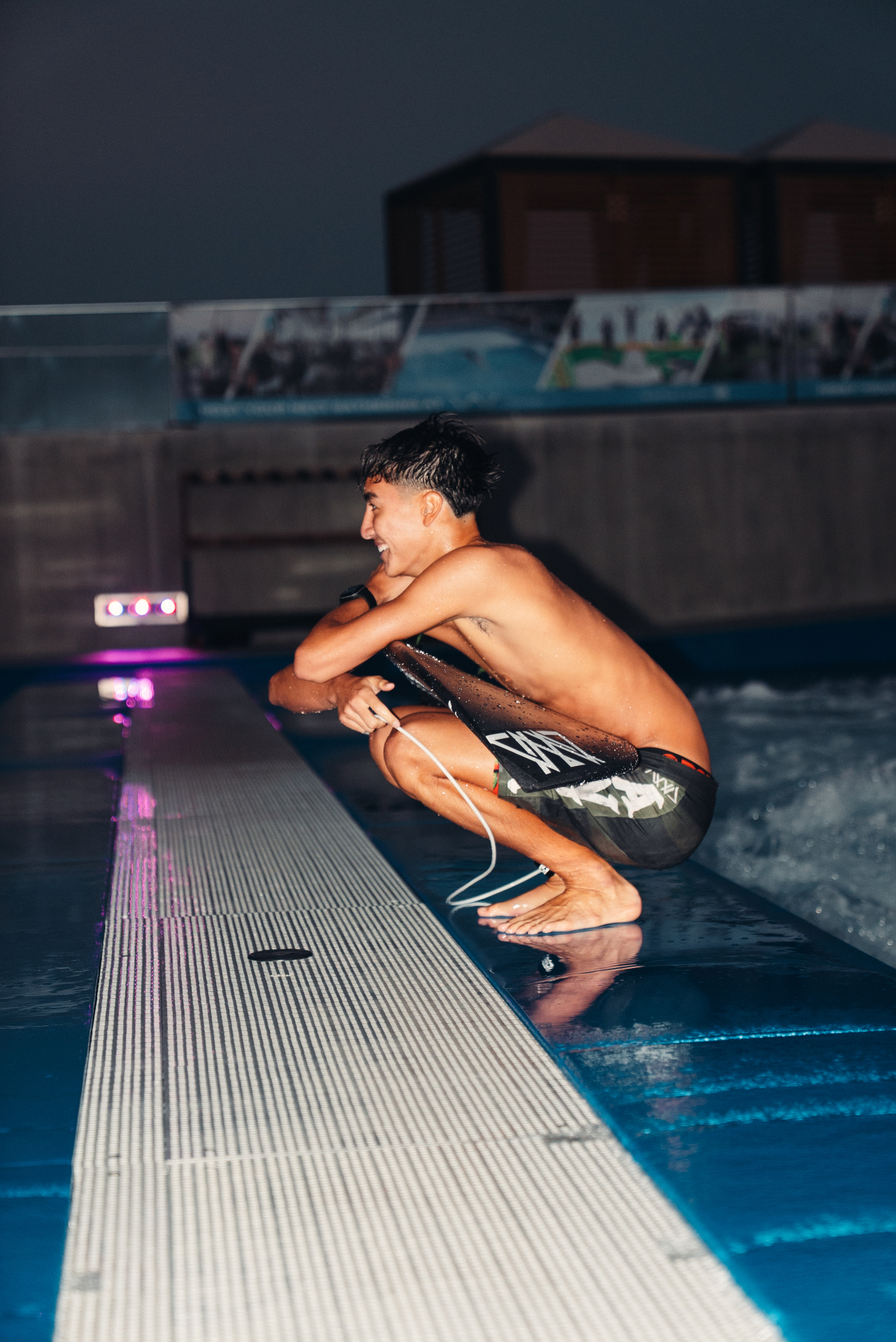 AVVA rider crouched poolside after a session