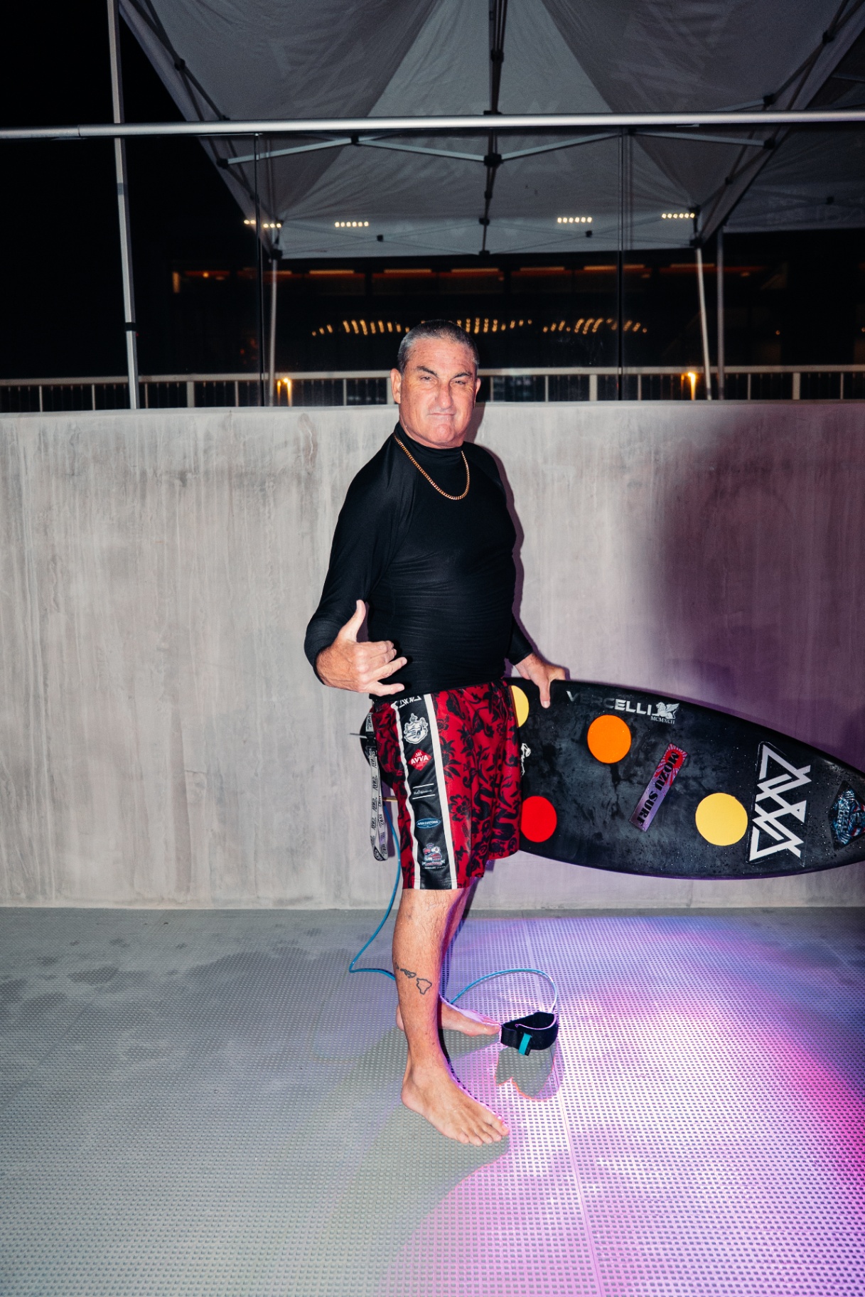AVVA waterman in red boardshorts with his board