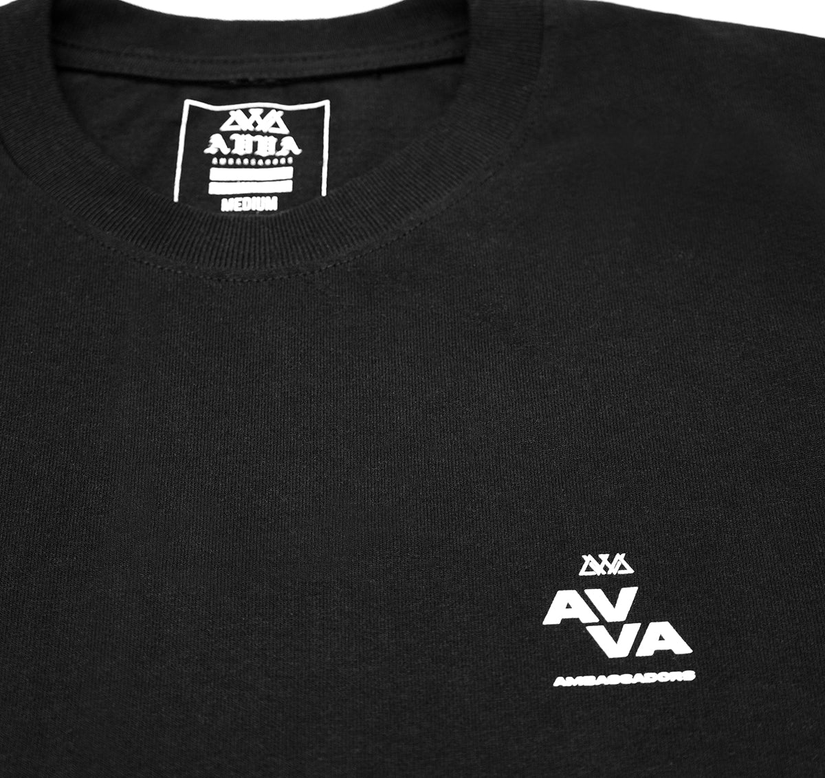 CLOSE UP OF TOP RIGHT SMALL AVVA LOGO ON THE FRONT OF THE TEE.