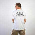 BACK VIEW OF KAHILI BEACH TEE ON MODEL WEARING IT LOOKING TO THE LEFT. HIGHLIGHTING THE BACK AVVA AMBASSADORS WITH ALOHA LOGO.