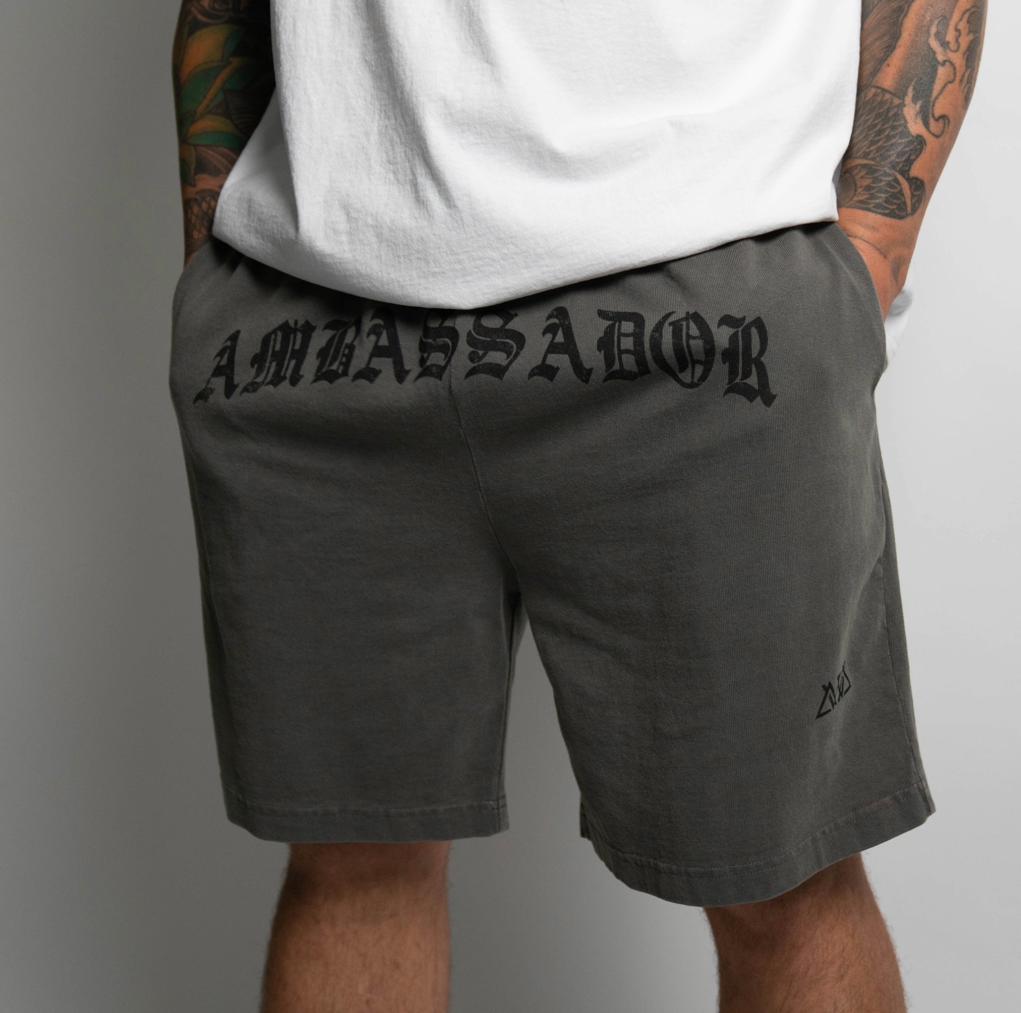 FRONT VIEW OF KHAKI PIGMENT DYED HILO SHORT ON MODEL WITH HANDS IN POCKETS.