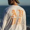 CLOSE UP OF BACK VIEW OF KEKOA WEARING SUN FADE WHITE LONG SLEEVE IN FRONT OF OCEAN