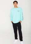 MODEL FACING FORWARD WITH HANDS IN POCKET WEARING BEACH STREETS MINT LONG SLEEVE TEE IN STUDIO