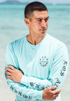 CLOSE UP OF MALE MODLE FACING TO THE SIDE WEARING BEACH STREETS MINT LONG SLEEVE TEE AT THE BEACH