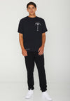 FRONT VIEW OF MODEL WEARING BLOOD PALMS BLACK TEE IN STUDIO.