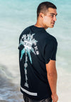 QUARTER BACK VIEW OF MALE MODEL WEARING BLOOD PALMS BLACK TEE AT THE BEACH