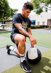 MALE MODEL IN TRAINING WEARING COAST TO COAST BLACK TEE.