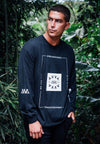 FRONT VIEW OF MALE MODEL WEARING DIESEL BLACK LONG SLEEVE IN JUNGLE. LARGE AVVA LOGO SCREEN PRINT DETAIL ON FRONT. SMALL AVVA LOGO ON SLEEVE. FRONT PRINT WE ARE THE AMBASSADORS WITH ALOHA