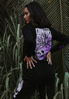 BACK VIEW OF MODEL WEARING ILLEST AMBASSADOR BLACK LONG SLEEVE TEE WITH GREENERY IN BACKGROUND