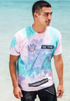 FRONT VIEW OF MODEL WEARING LOKAHI CORAL WASH TEE WITH OCEAN IN BACKGROUND
