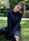 FRONT VIEW OF MODEL SHOWING OUTSIDE OF THE MADISON REVERSIBLE BLACK CREW SITTING ON GRASS