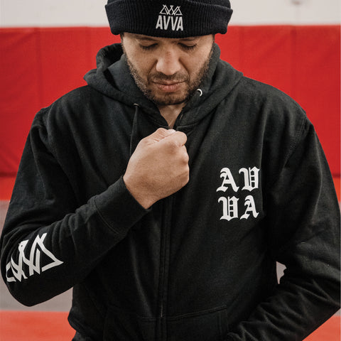 FRONT VIEW OF WRESTLER ZIPPING UP OCEAN SOUL ZIP UP BLACK HOODIE