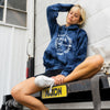 FRONT VIEW OF MODEL SITTING ON THE BACK OF A BOX TRUCK WEARING PURE ALOHA HOODIE