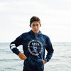 FRONT VIEW OF MODEL WEARING PURE ALOHA HOODIE WITH OCEAN IN BACKGROUND